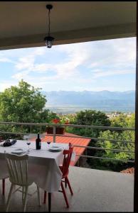 a table and chairs on a balcony with a view at Omsi House in Telavi