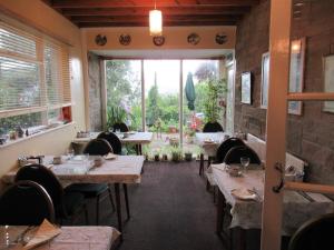 een restaurant met tafels en stoelen en een groot raam bij Avoncourt Lodge in Ilfracombe