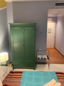 a green cabinet in a room with a bed at Hotel Elu Iris in Split