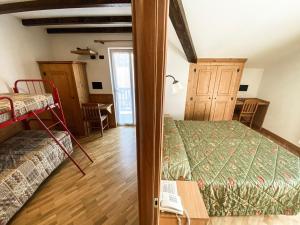 ein Schlafzimmer mit einem Bett und einem Tisch in einem Zimmer in der Unterkunft Garni Il Muretto in Lavarone