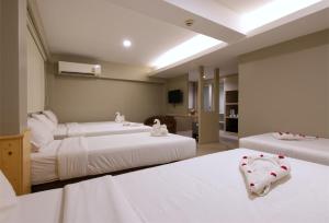 ein Schlafzimmer mit 2 Betten und ein Wohnzimmer in der Unterkunft Grand Alpine Hotel in Bangkok