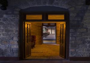 an open doorway into a room with a brick wall at The Tamara Kodai in Kodaikānāl