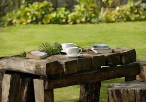 a wooden table with two coffee cups and books on it at The Tamara Kodai in Kodaikānāl
