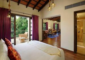 a bedroom with a bed and a living room at The Tamara Kodai in Kodaikānāl