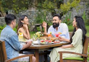 a group of people sitting around a table eating food at The Tamara Kodai in Kodaikānāl