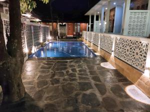 a swimming pool with a tree in the middle at The Royal Joglo in Tepus