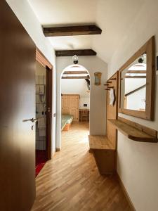 un couloir avec une porte et une chambre avec une table dans l'établissement Garni Il Muretto, à Lavarone