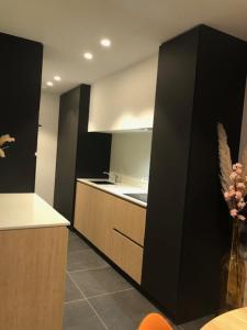 a kitchen with black and white cabinets and a sink at BLOC79/TWO in Knokke-Heist +17 photos