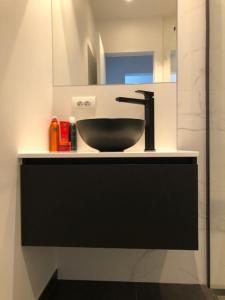a bathroom with a black sink and a mirror at BLOC79/TWO in Knokke-Heist