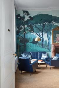 a living room with blue couches and a painting on the wall at O DELA DE L'O, LE 64 - maison d'hôtes de charme entre Côte d'Albâtre et Baie de Somme in Eu