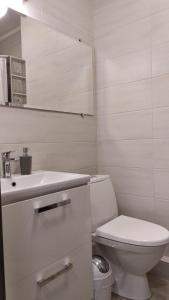 a white bathroom with a toilet and a sink at Fly Up Home apartment in Boryspilʼ +28 photos