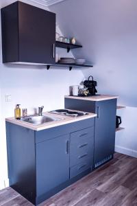 - une cuisine bleue avec évier et cuisinière dans l'établissement Flippi-s-Hues-WEST, à Westerland