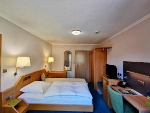 a hotel room with a bed and a television at Gasthaus zur Eiche in Hausach