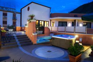 a house with a hot tub on a patio at Artemis Hotel in Cefalù