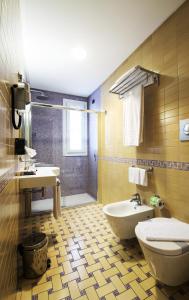 a bathroom with a toilet and a sink at Artemis Hotel in Cefalù