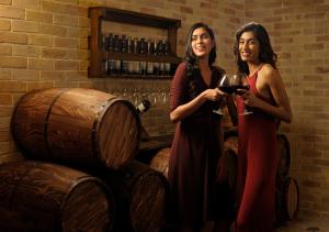 two women standing in a wine cellar holding wine glasses at The Tamara Kodai in Kodaikānāl