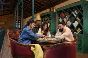 a group of people sitting around a table playing poker at The Tamara Kodai in Kodaikānāl