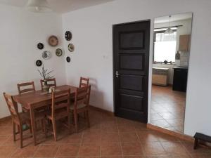 a kitchen and dining room with a table and chairs at Szira Porta in Hollókő