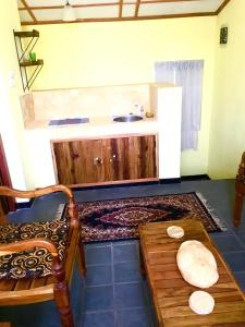 cocina con fregadero y mesa de madera en Owl's Nest Chalet en Udawalawe