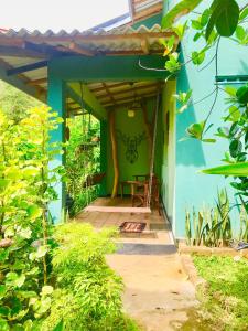 mały niebieski dom ze stołem w drzwiach w obiekcie Owl's Nest Chalet w mieście Udawalawe