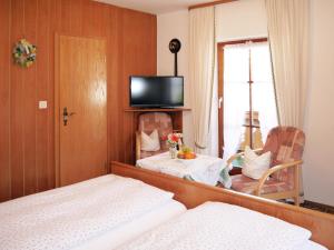 1 dormitorio con cama, mesa y espejo en Gästehaus Alfred Klais en Krün
