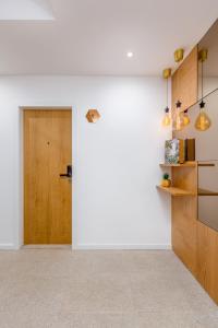 um corredor com uma porta de madeira e paredes brancas em Nell&And&Jess em Espinho