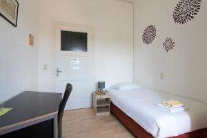 a small bedroom with a bed and a desk at World House Wetten in Kevelaer