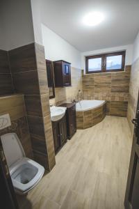 łazienka z 2 umywalkami, wanną i toaletą w obiekcie Chata u Pinkasů w Jabłonkowie