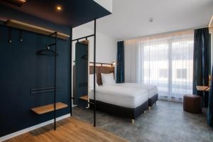 a bedroom with a bed and a large window at H2 Hotel Budapest in Budapest