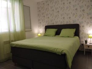 a bedroom with a bed with green sheets and a window at La Cigale - Pte des Gorges - Piscine privée chauffée in Vallon-Pont-dʼArc +28 photos