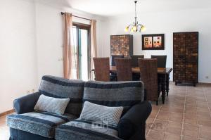 Una sala de estar con un sofá y un comedor. en Finca Verdal, en Alquería Blanca