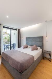 a bedroom with a large bed and a table at Nell&And&Jess in Espinho