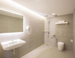 a bathroom with a sink and a toilet and a mirror at Minimalist Hotel in Johor Bahru