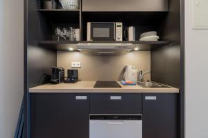 uma cozinha com um lavatório e um micro-ondas em Nena Apartments - Kreuzberg 61 em Berlim