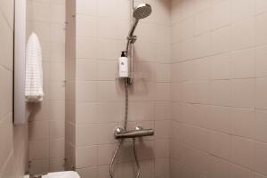 łazienka z prysznicem z głowicą prysznicową w obiekcie Roost Roobert 3 w Helsinkach