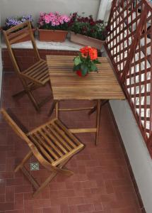 a wooden table and chairs and flowers on a balcony at B&B Dietro l'Angolo in Benevento