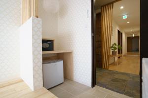 a hallway of a house with a tv and a room at Hotel San Hiroshima in Hiroshima