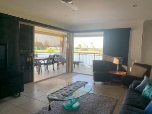 a living room with a couch and a glass table at Riverview Apartment in Yamba