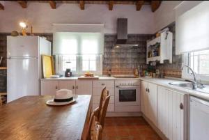 uma cozinha com uma mesa de madeira com um chapéu em Chalet Piscina Roche em Cádiz