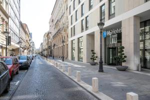 a city street with cars parked on the side of the street at H2 Hotel Budapest in Budapest