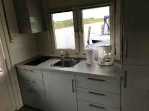eine Küchentheke mit einem Waschbecken und einem Fenster in der Unterkunft Waterhut 2 Aduarderzijl in Feerwerd