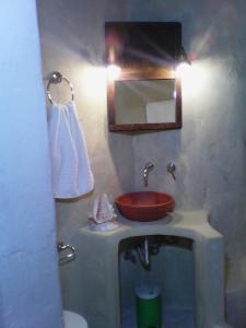 a bathroom with a red sink and a mirror at Aperando in Tolo