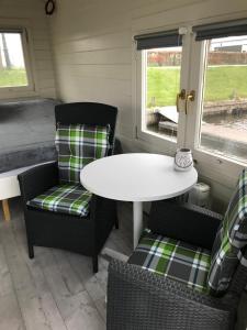 ein Tisch und Stühle in einem winzigen Haus in der Unterkunft Waterhut 2 Aduarderzijl in Feerwerd