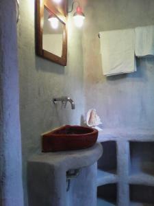 a bathroom with a wooden sink and a mirror at Aperando in Tolo
