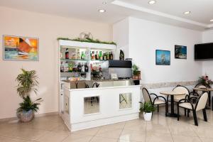 a bar with a counter and chairs in a room at Albergo Gloria in Bellaria-Igea Marina