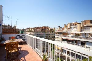 a balcony with a table and chairs and buildings at Attic Bcn Central Terrace in Barcelona