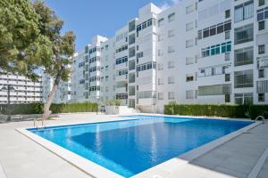 a swimming pool in front of a building at Rentalmar family Anagabu in Salou