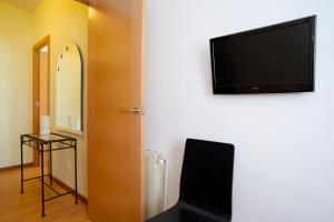 a room with a flat screen tv on a wall at Attic Bcn Central Terrace in Barcelona