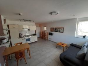 a living room with a couch and a table and a kitchen at Ferienwohnung Goltz in Thüngersheim