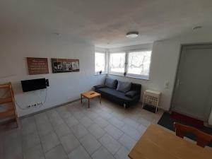 a living room with a blue couch and a table at Ferienwohnung Goltz in Thüngersheim